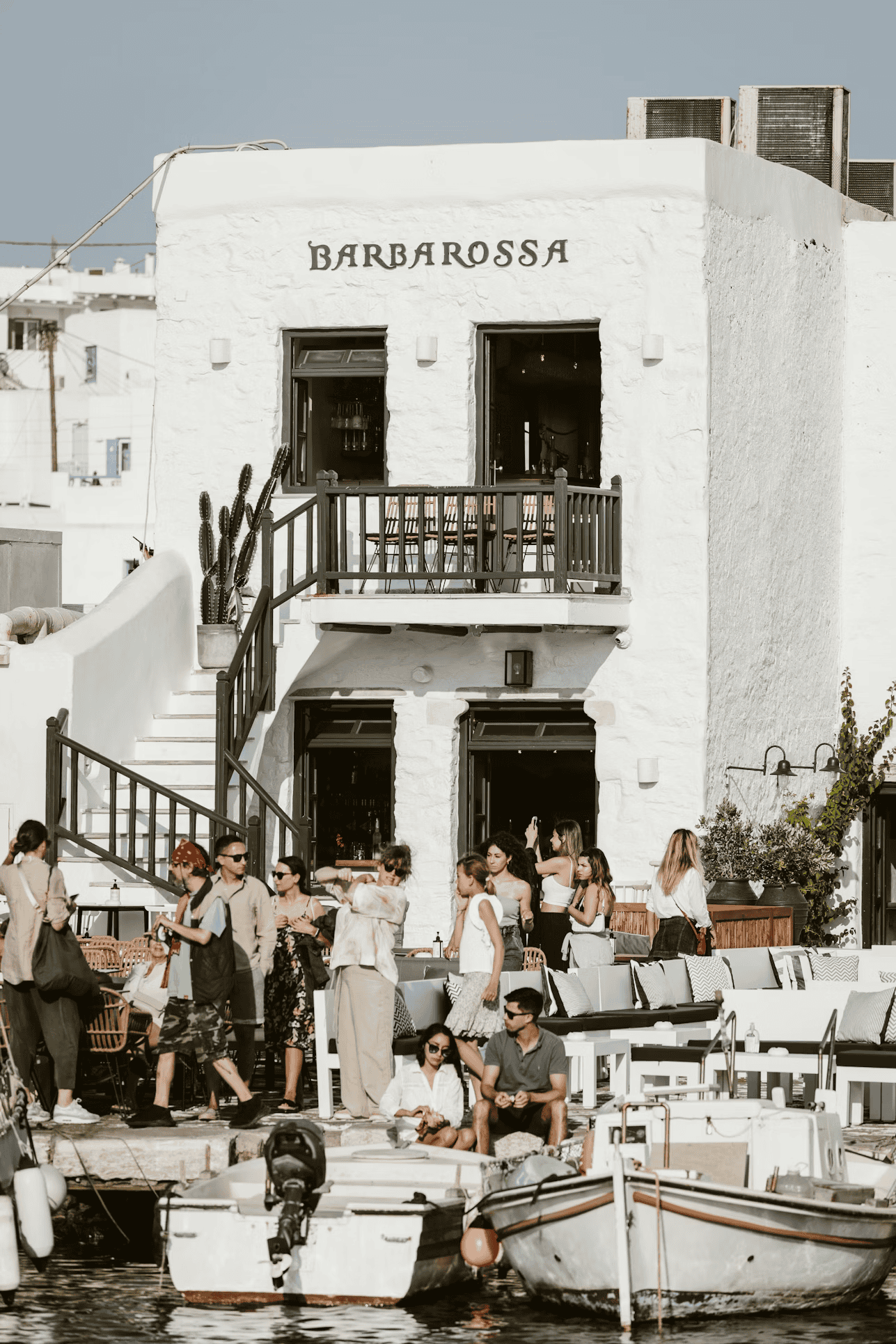 Cyclades island Paros: charming white building with outdoor seating and visitors.