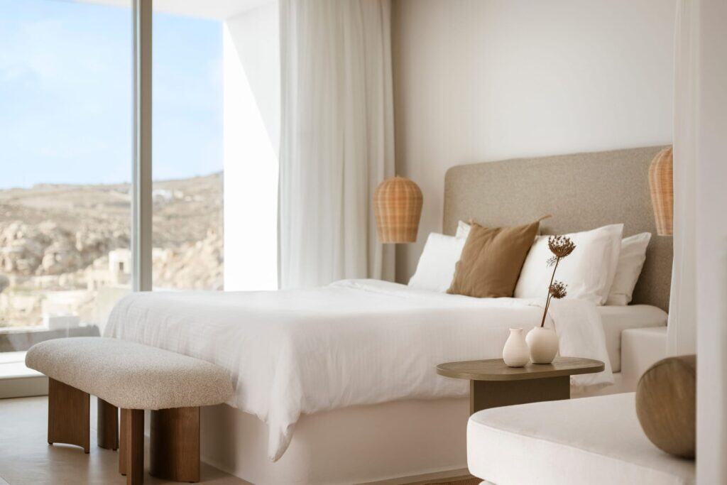 Luxury pool suite with side sea view in the Cyclades, 35m², modern decor, and stunning ocean vistas.