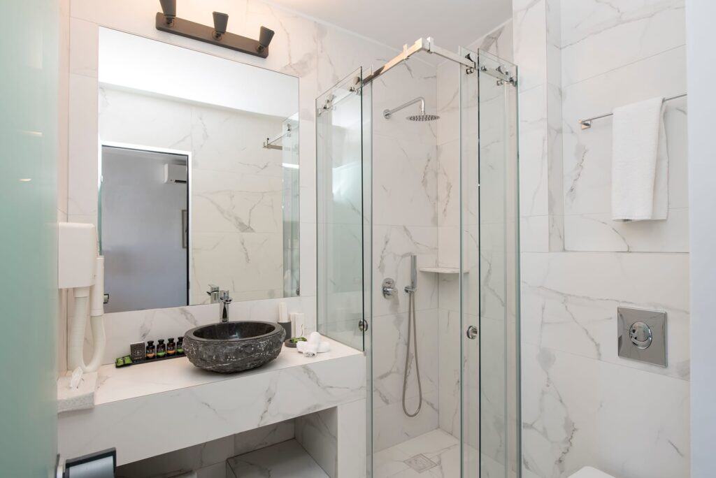 Modern bathroom with walk-in shower and marble accents at Mr and Mrs White Hotels Cyclades.