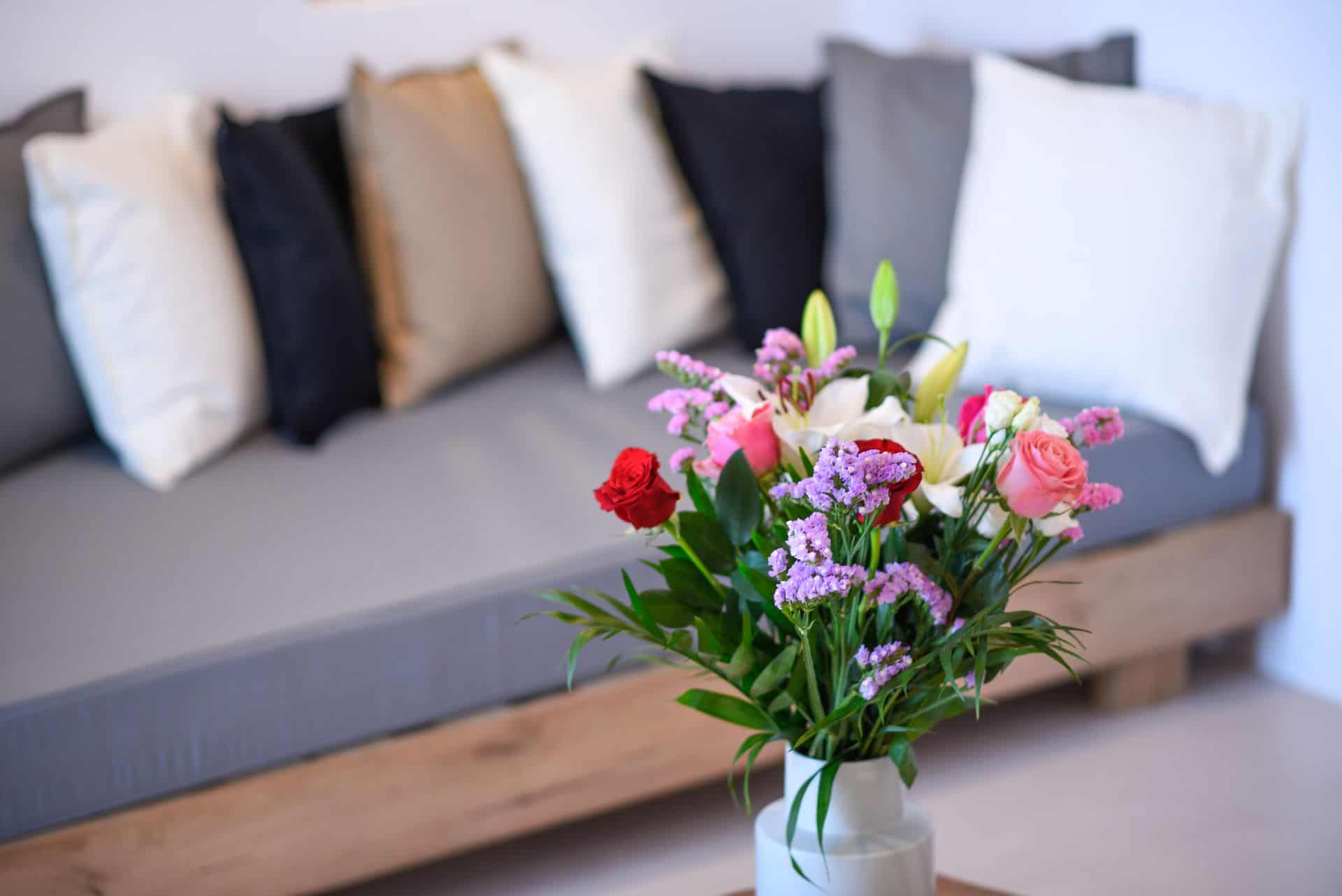 Cozy master suite with colorful flower arrangement and plush pillows, featuring a private plunge poo.