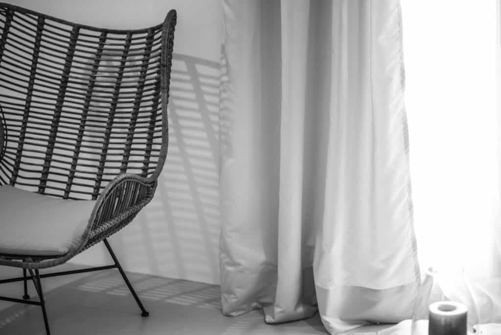 Elegant wicker chair beside white curtains in the Executive Suite with Plunge Pool at Mr and Mrs Whi.