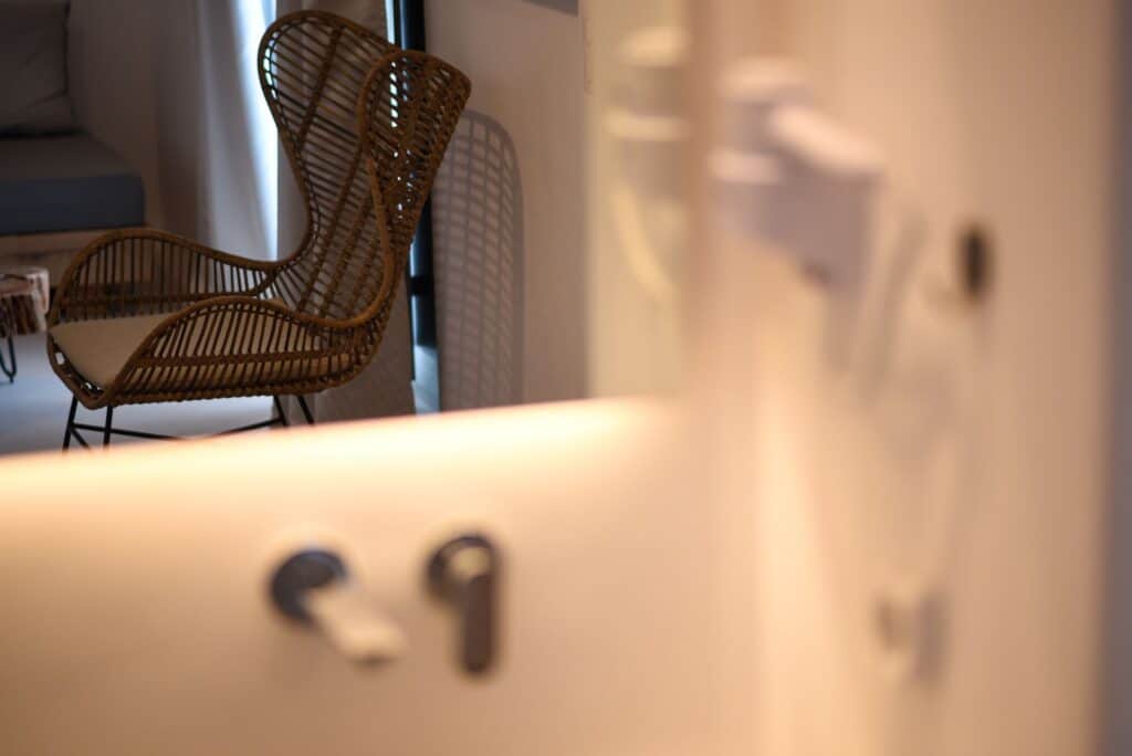Elegant rattan chair in a modern hotel suite with private plunge pool in the Cyclades. Perfect for a.