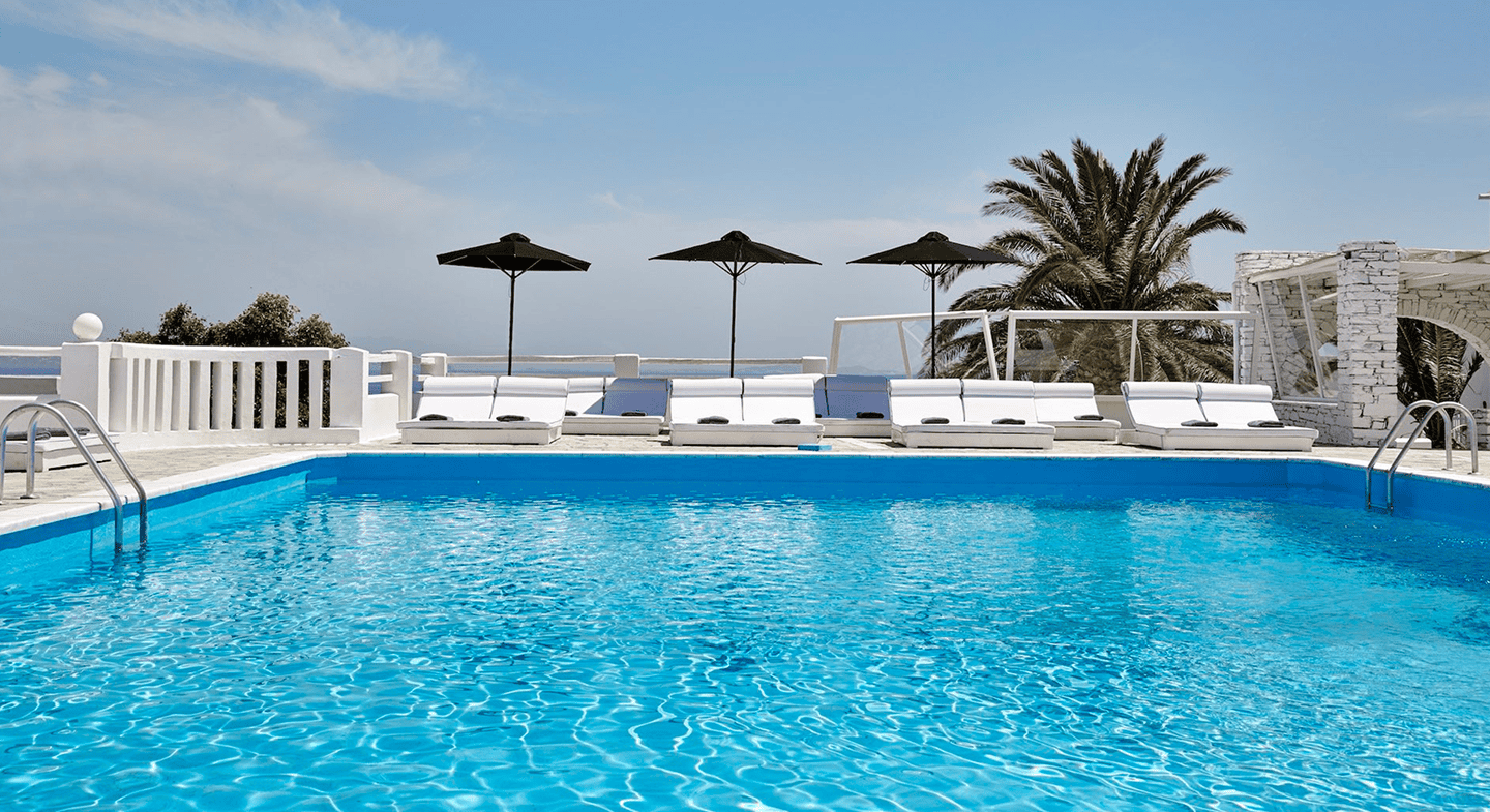 Pool with sun loungers and umbrellas in Tinos, Cyclades.