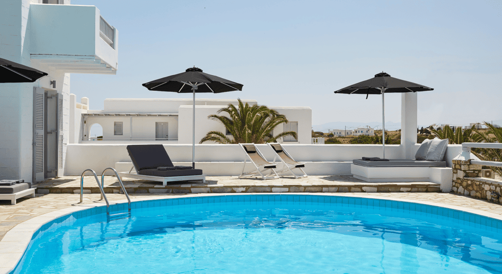 Pool area with sun loungers and umbrellas at Mrs Armelina, a luxury hotel in the Cyclades.