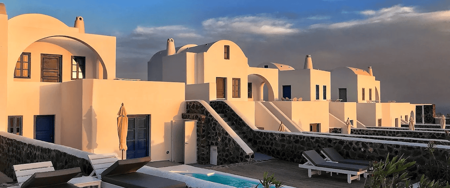 Luxury Villas Santorini with whitewashed walls and blue accents. Perfect for a romantic getaway at M.