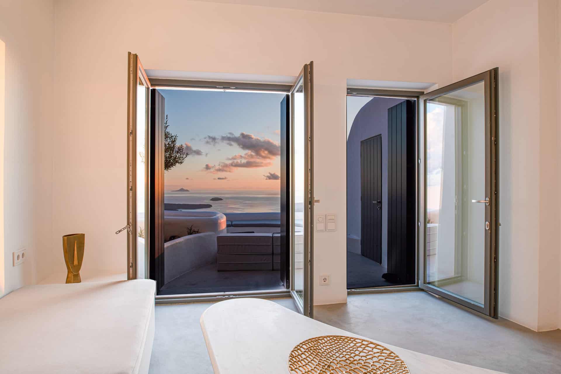 Stunning view from Heavens Edge Villa with indoor pool and open doors to outdoor sea scenery.