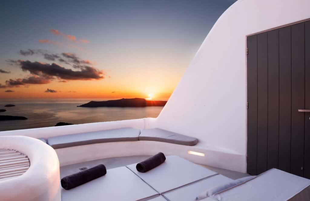 Stunning sunset view from Heavens Edge Villa with outdoor seating in Cyclades.