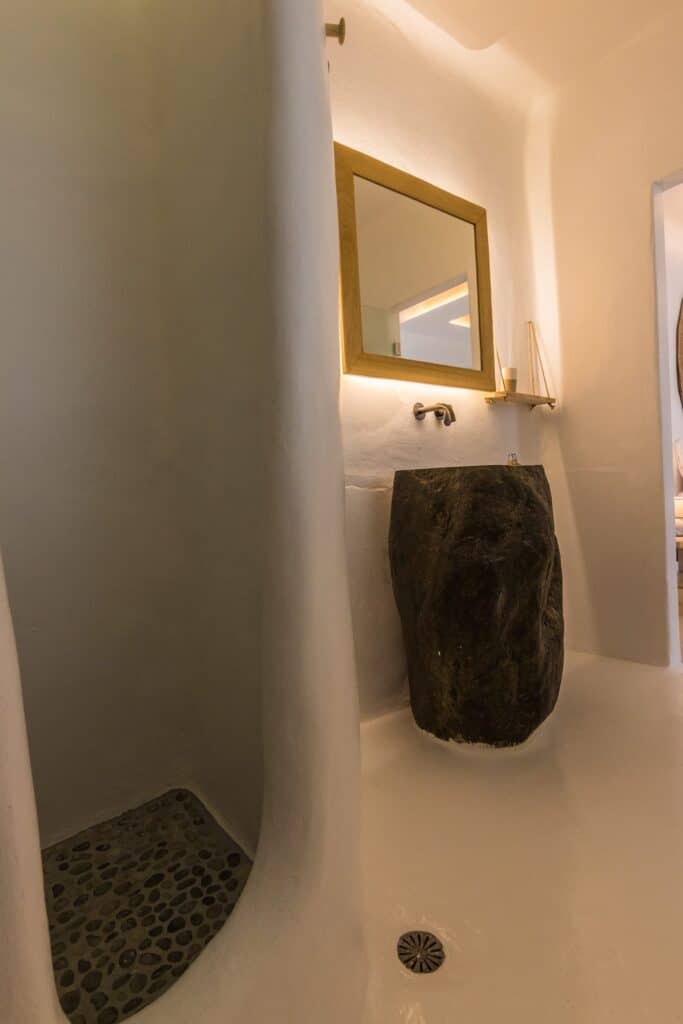 Modern bathroom with natural stone sink and minimalist decor at Mr and Mrs White Hotels Cyclades.
