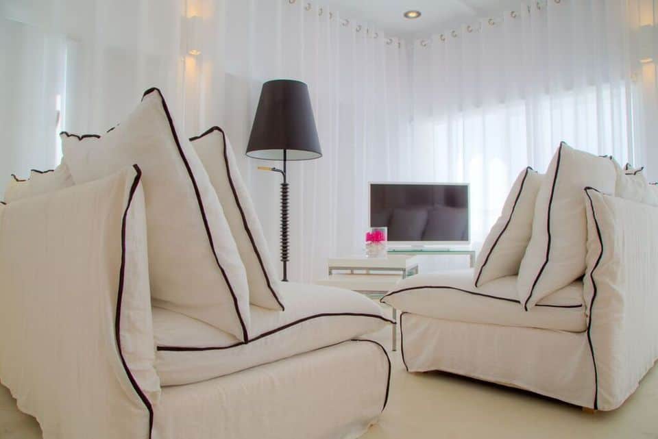 Elegant living room with white sofas and sea view.