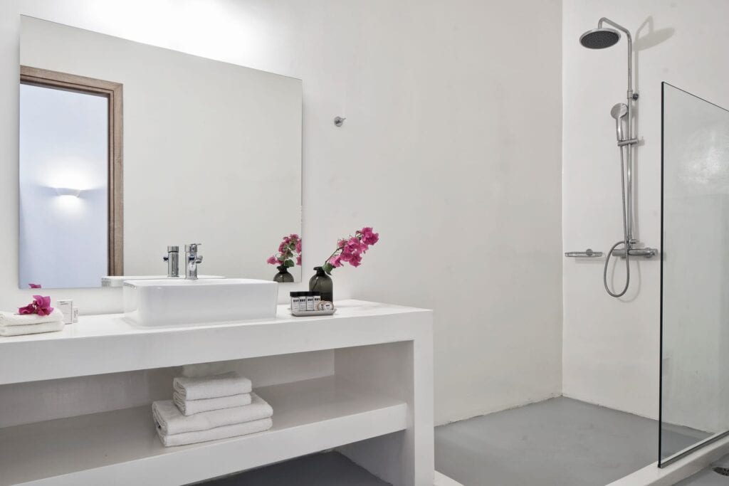 Modern Cyclades suite bathroom with garden view, featuring a spacious walk-in shower and minimalist.
