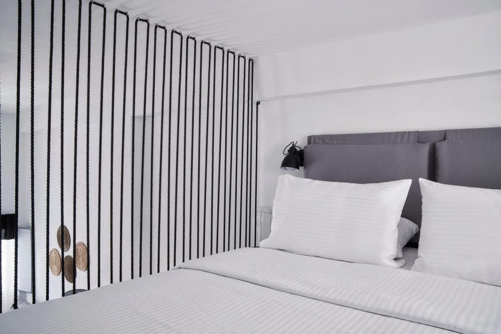 Caldera view superior room with modern decor and comfortable bedding in the Cyclades. Perfect for a.