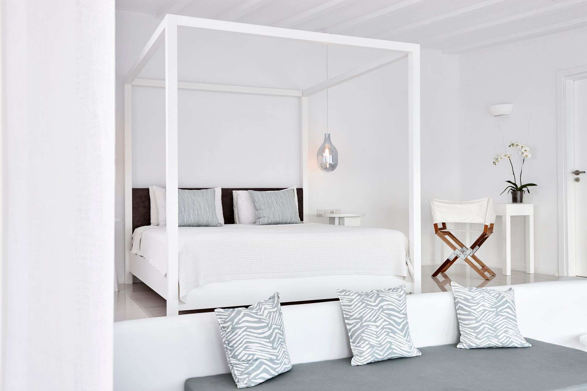 Elegant sea view Notos Suite with modern decor and white furnishings.