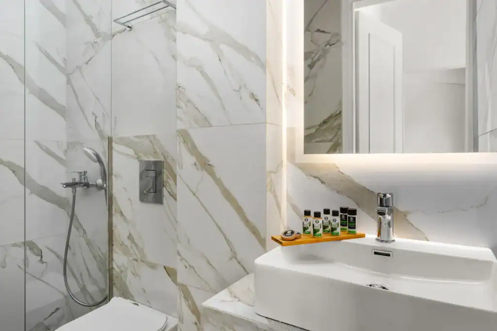 Modern marble bathroom with walk-in shower and sleek fixtures.