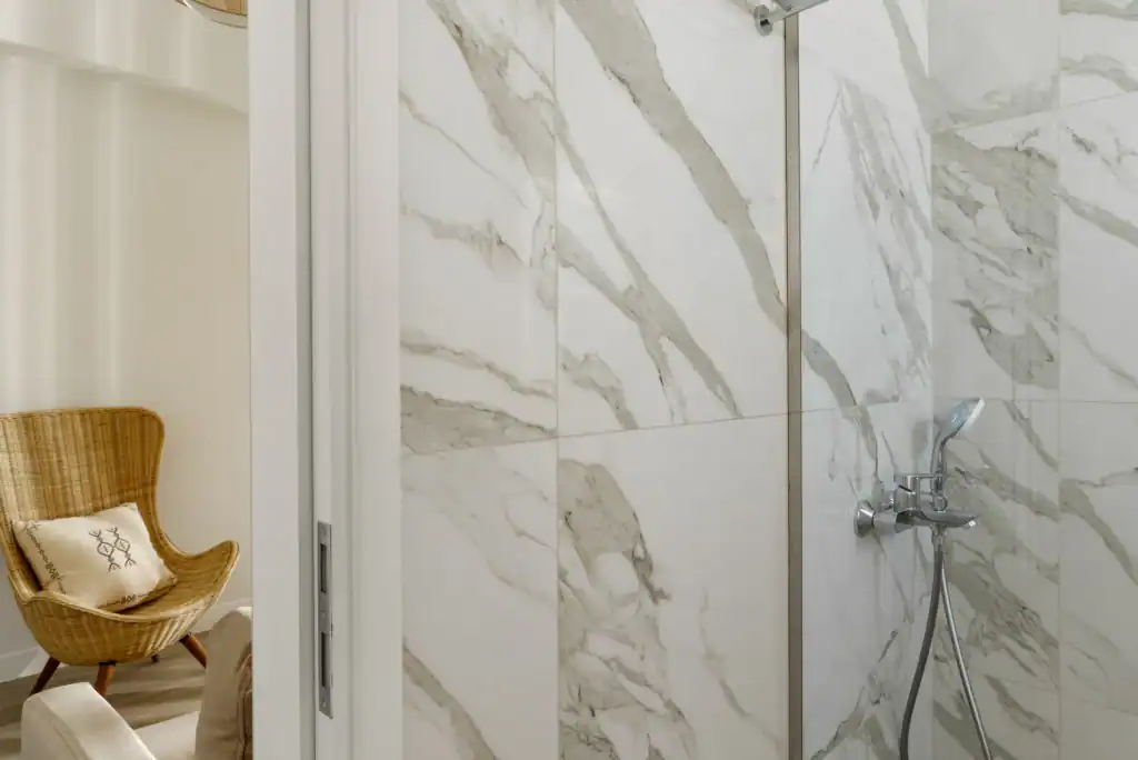 Sea View Suite Bathroom with Marble Walls and Shower.