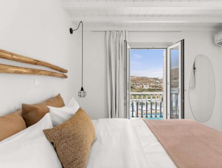 Sea view triple room with balcony, modern decor, and bright natural light at Mr and Mrs White Hotels.