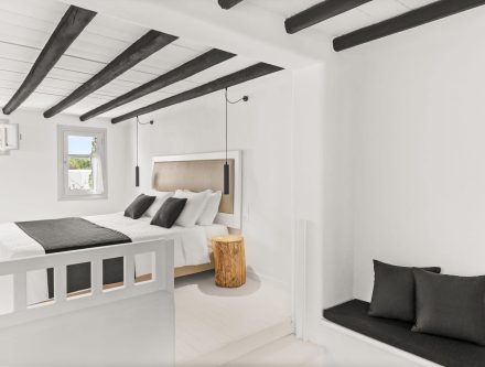 Modern two-floor residence with garden view, white interior, black accents, and wooden details.