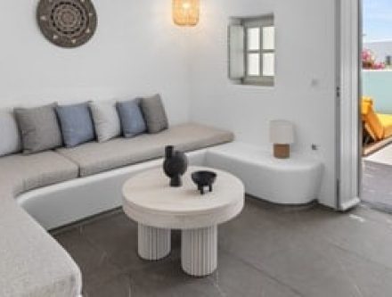 Stylish living room with sofa, coffee table, and access to private pool terrace in Cyclades.