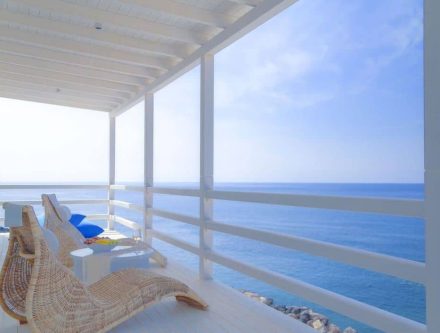 Sea View Notos Suite balcony with ocean view, relaxing lounge chairs, and white modern decor.