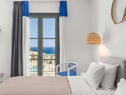 Elegant junior suite with sea view, upper floor, modern decor, and balcony in Mr and Mrs White Hotel.
