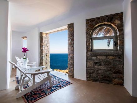 Sea view from deluxe suite with stone accents and white decor.
