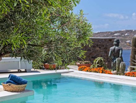 Elegant Cyclades villa with private pool, sea view, and lush greenery in the Greek islands.